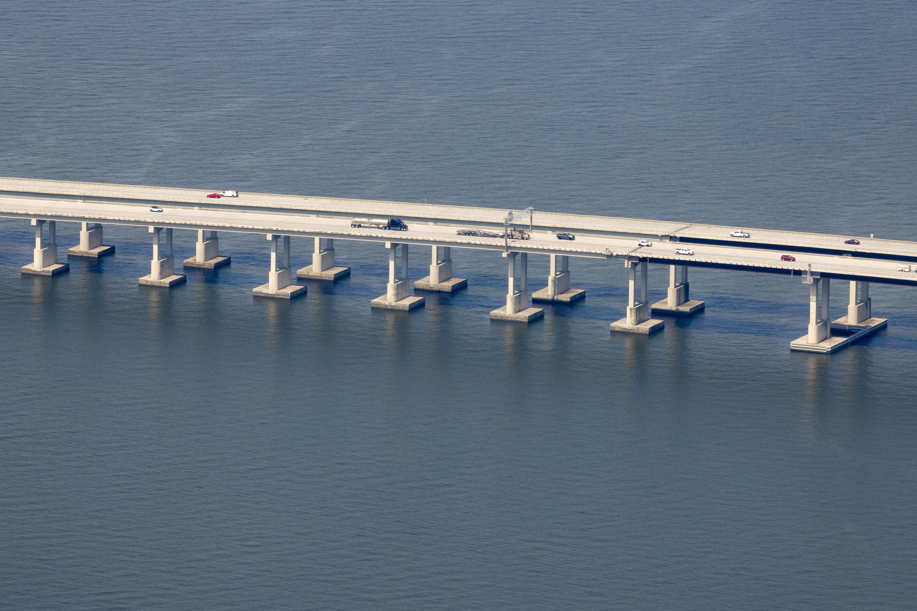 03-TWINSPAN A view of a long bridge over a lake with shoulders on both sides of the bridge.